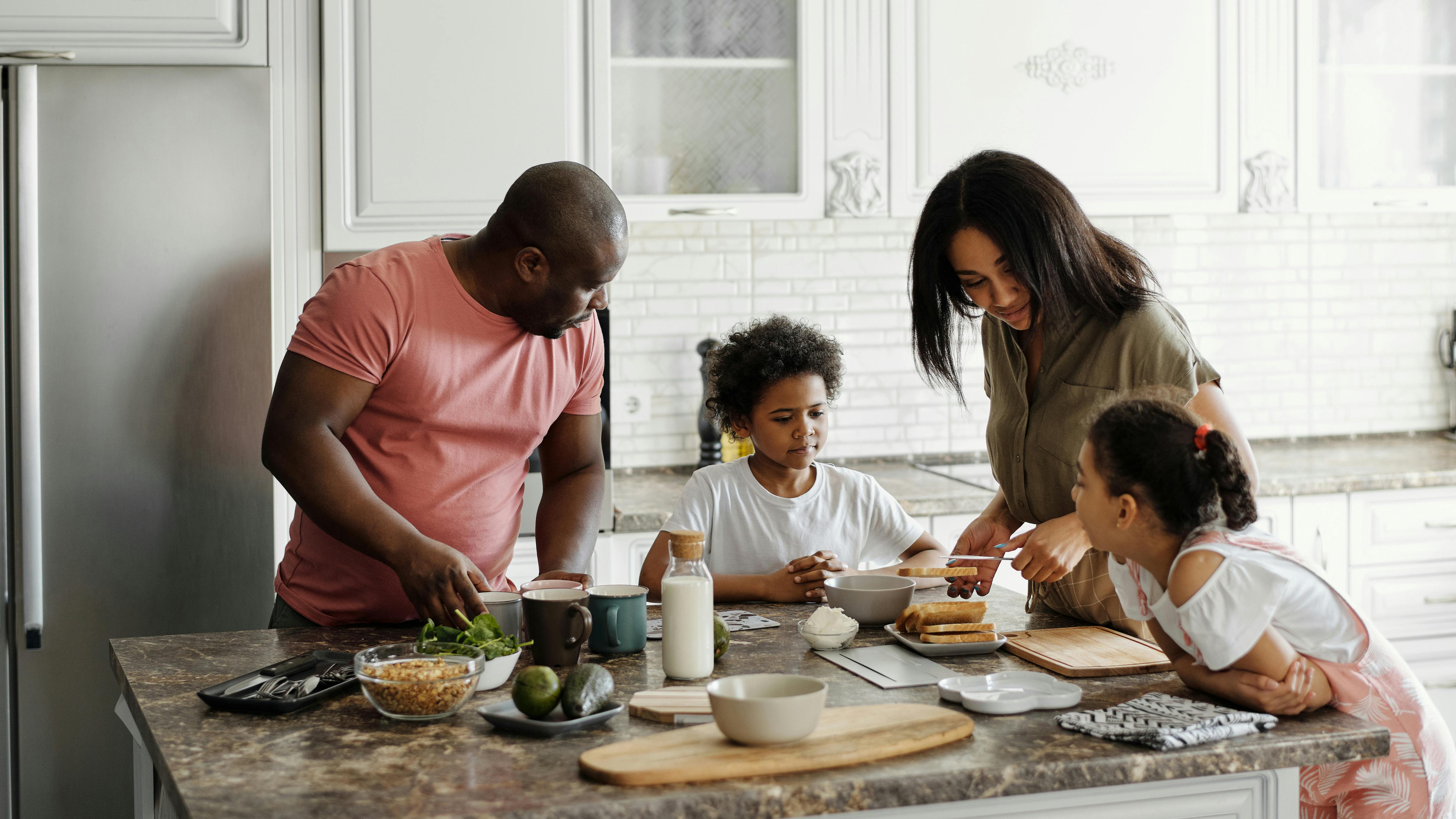 Famille préparant le petit-déjeuner ensemble dans une cuisine canadienne